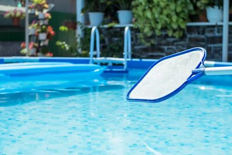 Net-skimmer in the background of a pool with clear water and with an air matt Stock Photos