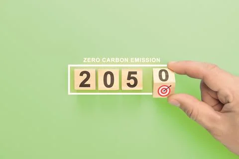 Net zero by 2050. hand holding wooden cube with target. Low carbon,carbon neu Stock Photos