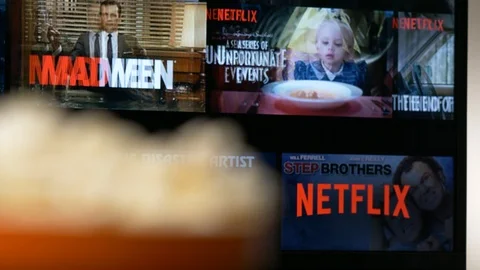 Netflix on and Popcorn on a Table Focus Pull Between The Two Stock Footage 92645007