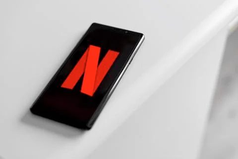 Netflix company logo on the smartphone screen. Stock Photos