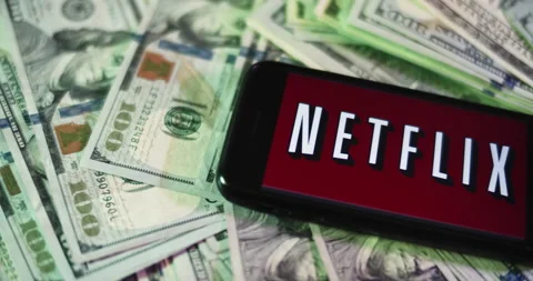 Netflix Logo on iphone surrounded by $100 Bills. Netflix Profits Layout. Stock Footage 169008505