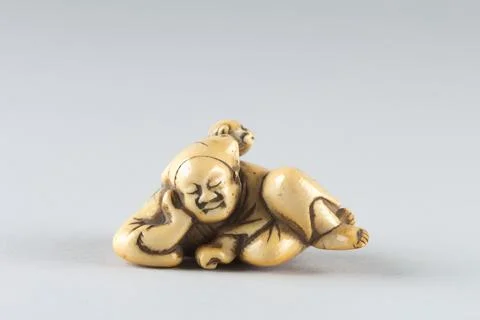 Netsuke of a Man Sleeping while Monkey Steals Contents of Basket 19th centu.. Stock Photos