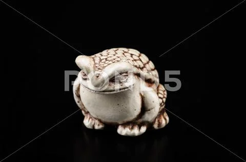 Netsuke toad on black Stock Photos
