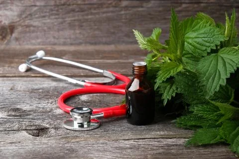 Nettle leaf extract and stethoscope on wooden background Foto stock
