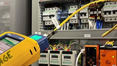 Network administrator using a cable tester to verify ethernet connections in a Stock Footage 341543916