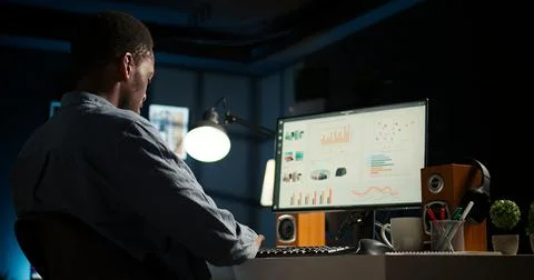 Network analyst studying digital commerce progression reports on computer Stock Photos