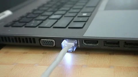 The network cable is being connected to the laptop. The network connection Stock Footage 196803359