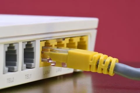 Network cable connected to internet router on metal table Stock-Fotos