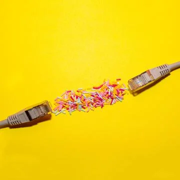 Network cable connected with sprinkles on yellow background. Creative flat lay.  Stock Photos
