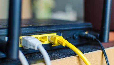 Network cable connected into a wireless router Stock Photos