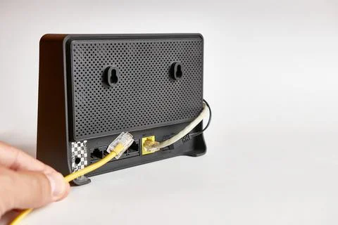 A network cable for connecting to the Internet is connected to the router. Stock Photos