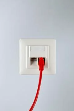 A network cable plugged into a wall socket Stock Photos