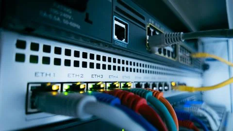Network cables and glowing lights on professional data switch, representing.. Stock Photos