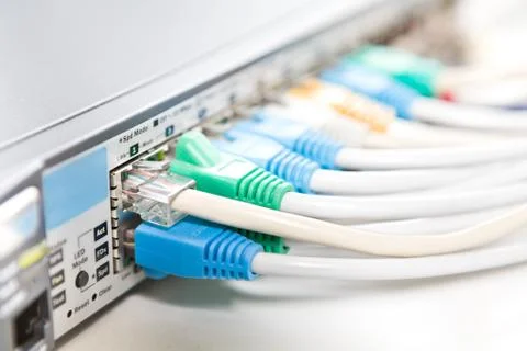 Network cables connected into router, shallow DOF Stock Photos