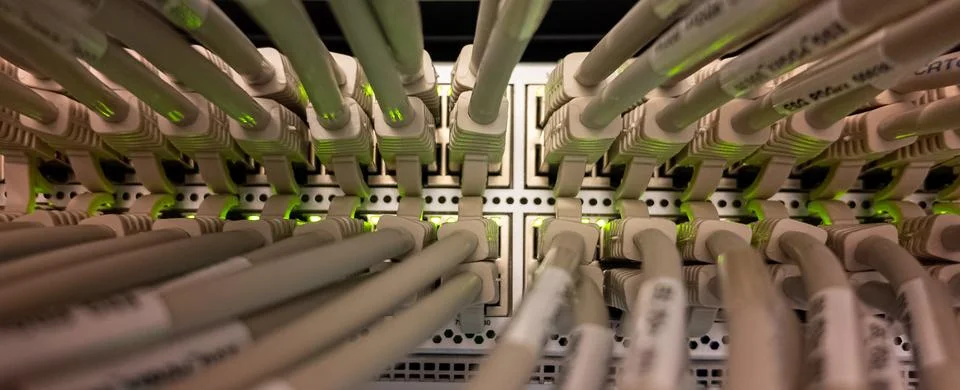 Network cables connected to a switch in a data center with green lights Stock Photos