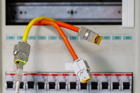 Network cables connecting into an electrical panel Stock Photos