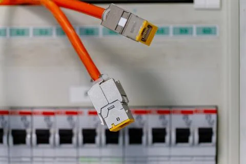 Network cables connecting into an electrical panel Stock Photos