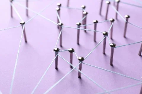 Network connection. Nails linked together by thread on violet background, c.. Stock Photos