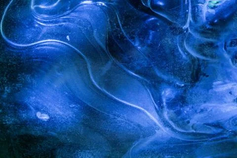 Network of cracks in thick solid frozen layer of ice with shining light Foto stock