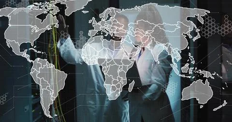 Network engineer and data analyst verifying CAT cable connections with map ov Stock Photos