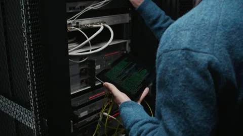 Network Engineer Checking Server Rack with Tablet and Cable Coil Stock Footage 330543615