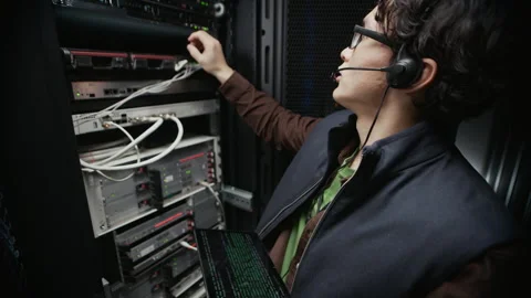 Network Engineer Configuring Server Rack with Tablet in Data Center Stock Footage 330541852