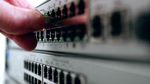 Network engineer connects Ethernet cable on computer switch Stock Footage 204714101