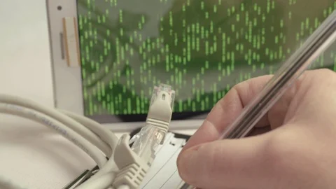Network engineer making notes with ethernet cables with green binary data Stock Footage 126030460