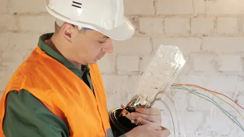 A network engineer in a server room with an optical cable. Stock Footage 89221175
