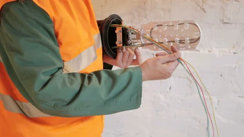 A network engineer in a server room with an optical cable. Stock Footage 89222946