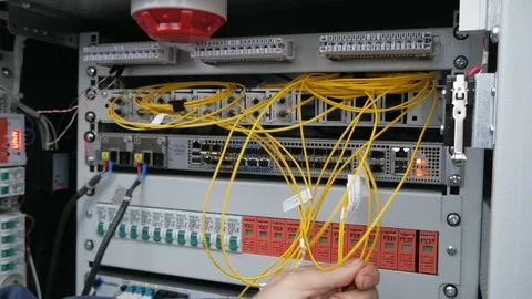 A network engineer in a server room with an optical cable. Stock Footage 126951339