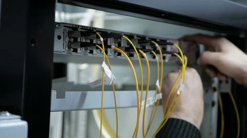 Network engineer in server room works with optical patchcord and optical module. Stock Footage 126954013