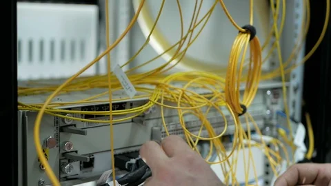 Network engineer in server room works with optical patchcord and optical module. Stock Footage 126954968