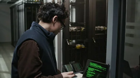Network Engineer Using Tablet and Laptop with Green Code in Data Center Stock Footage 330545027