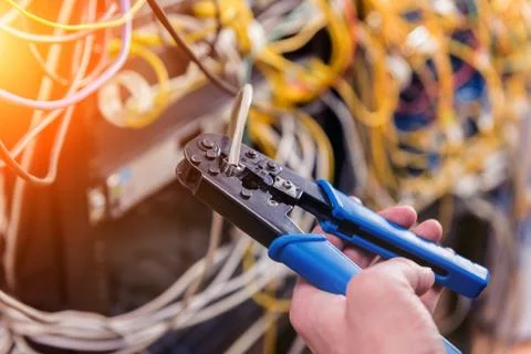 Network engineer working in server room. Connecting network cables to switches Stock Photos