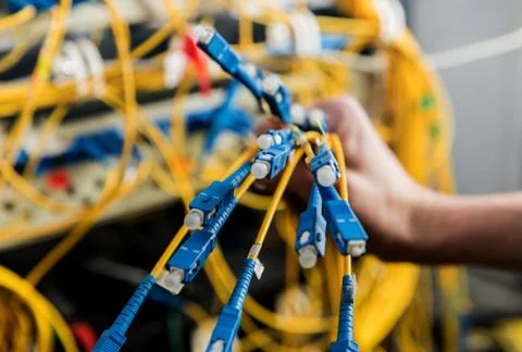 Network engineer working in server room. Connecting network cables to switches Stock Photos