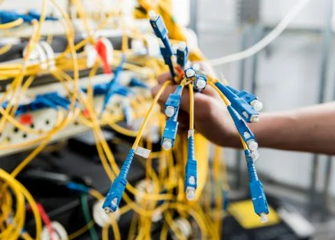 Network engineer working in server room. Connecting network cables to switches Stock Photos