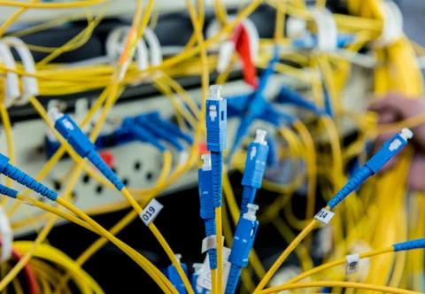 Network engineer working in server room. Connecting network cables to switches Stock Photos