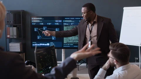 Network Engineers Discussing Cybersecurity Data during Presentation in Office Stock Footage 334932316