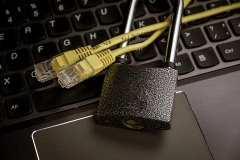 Network ethernet cables in padlock on black computer keyboard. Stock Photos