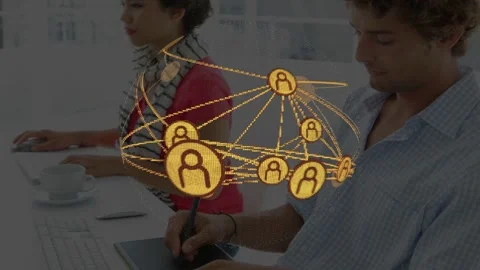 Network globe appearing above desk, rotating nodes while coworkers using devices Stock Footage 333689086