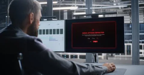 Network Operations Engineer Responds to DDoS Attack Across Data Center Stock Photos