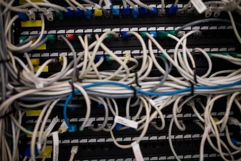Network patch panel is being shown with tangled Ethernet cables and RJ45 Foto stock