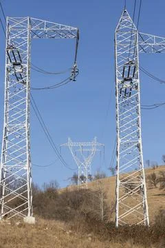 A network of power lines in a field Stock Photos