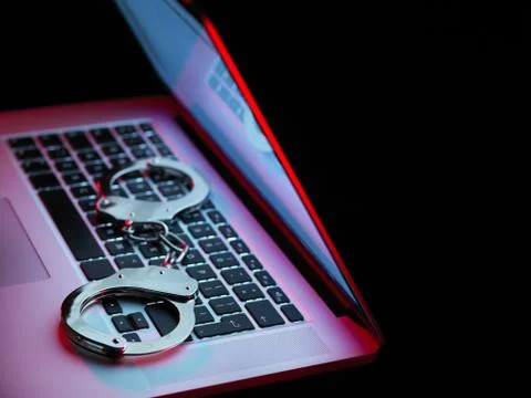 Network security, set of handcuffs sitting on laptop computer Stock Photos