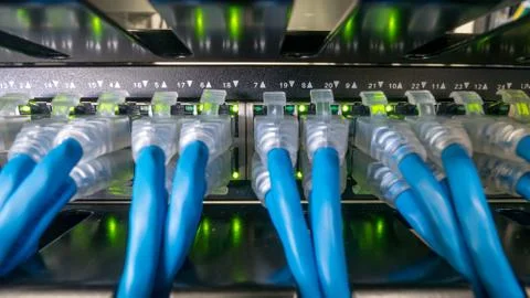 Network switch and ethernet cables connected in rack cabinet Stock Photos