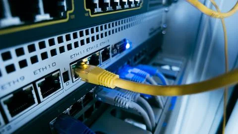 Network switch with yellow ethernet cable connected to port, showing modern.. Stock Photos