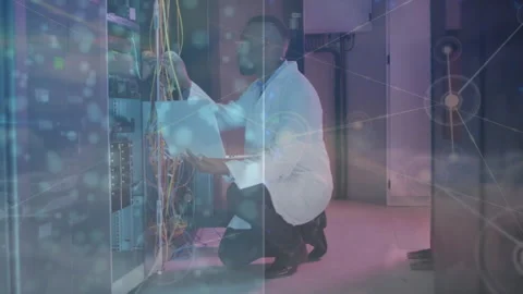 Network tech kneeling by rack running tests tracing cable to port with data Stock Footage 314453844