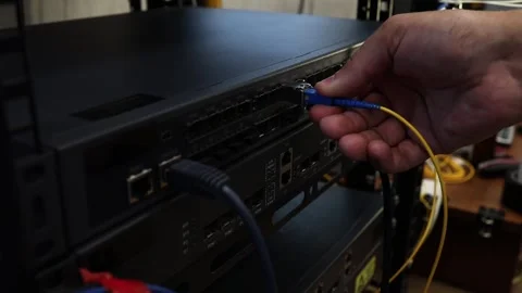 Network technician connects and checks cables on a network switch Stock Footage 278149953