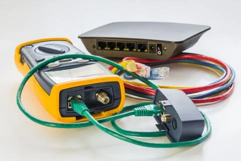 Network tester and small switch with various color RJ45 cables c Fotos Stock
